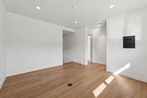 Spare room featuring attic access, recessed lighting, light wood-type flooring, and electric panel