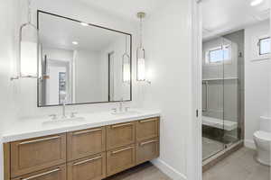 Full bath with double vanity, a stall shower, recessed lighting, and light tile patterned floors