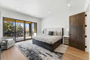Bedroom with access to exterior, light wood finished floors, and recessed lighting