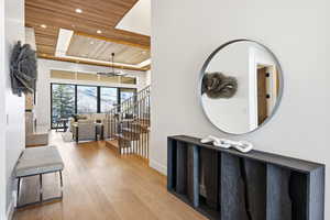 Hallway with wood ceiling, a raised ceiling, recessed lighting, hardwood / wood-style floors, and stairway
