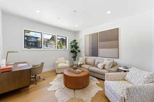 Living area with a desk, wood finished floors, and recessed lighting
