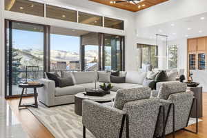Living room featuring a mountain view, light wood-style floors, wooden ceiling, and wine cooler