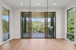 Doorway with wood finished floors, a mountain view, healthy amount of natural light, and recessed lighting