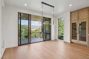 Doorway to outside with beverage cooler, wood finished floors, recessed lighting, and a mountain view