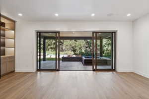 Doorway to outside featuring healthy amount of natural light, wood finished floors, and recessed lighting