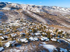 Snowy aerial view featuring a mountain view and a residential view
