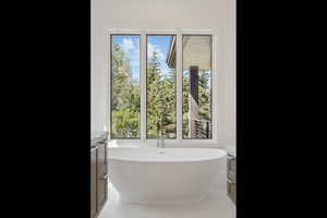 Full bathroom featuring a soaking tub and light tile patterned floors