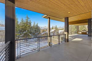 Snow covered back of property featuring a patio area, a mountain view, and area for grilling