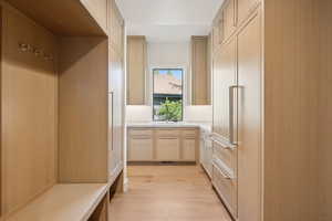 Mudroom featuring light wood-style floors and a sink