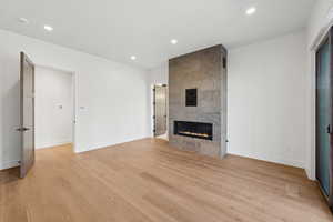 Unfurnished living room with recessed lighting, light wood-style flooring, and a fireplace