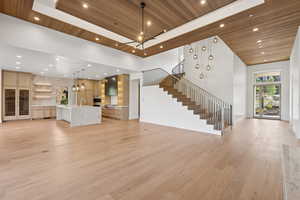 Unfurnished living room featuring wood ceiling, light wood-style floors, stairway, and recessed lighting