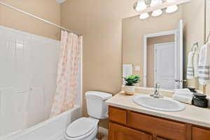 Bathroom featuring shower / bathtub combination with curtain and vanity
