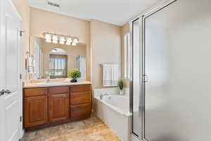 Full bath with a shower stall, vanity, and a garden tub