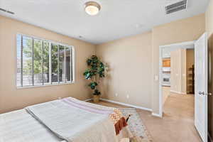 Bedroom featuring light colored carpet and baseboards