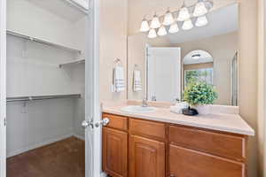 Bathroom with a walk in closet and vanity
