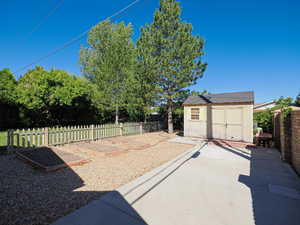 Fenced backyard featuring a garden and a shed
