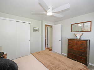 Bedroom featuring light colored carpet, a closet, and a ceiling fan