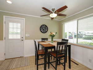 Dining area featuring plenty of natural light, light tile patterned floors, crown molding, and a ceiling fan
