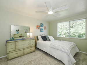 Bedroom featuring light carpet and a ceiling fan