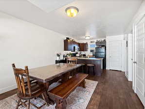 Dining space with dark wood finished floors and a textured ceiling