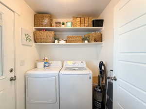 Washroom with a textured ceiling and washer and clothes dryer
