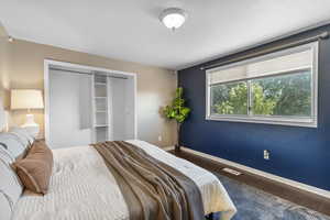 Bedroom with wood finished floors and a closet