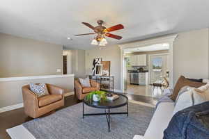 Living room featuring a ceiling fan and light wood-style flooring