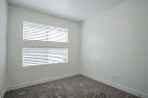 Carpeted empty room featuring baseboards