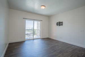 Unfurnished room with dark wood-type flooring