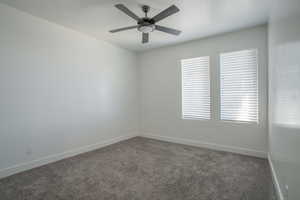 Empty room featuring carpet and a ceiling fan