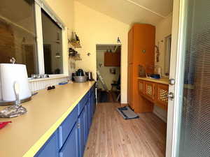 Bathroom with light wood-style floors and vaulted ceiling