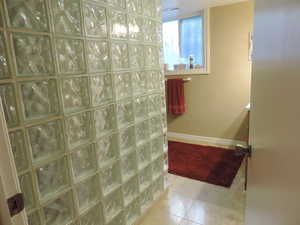 Bathroom featuring walk in shower, vanity, and light tile patterned floors