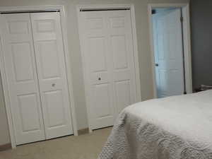 Primary Bedroom with two closets and light colored carpet