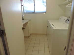 Washroom featuring light tile patterned floors and separate washer and dryer