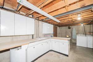 Unfinished below grade area featuring washer and dryer and a sink