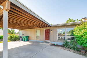 Entrance to property featuring a carport and concrete driveway