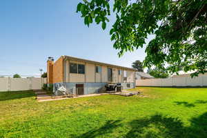 Back of property featuring a fenced backyard, a patio, and a chimney