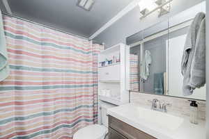 Bathroom featuring decorative backsplash, vanity, and curtained shower