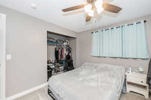 Bedroom with carpet, a closet, and a ceiling fan