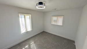 Unfurnished room with healthy amount of natural light and carpet flooring