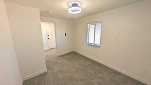 Spare room with carpet and a textured ceiling