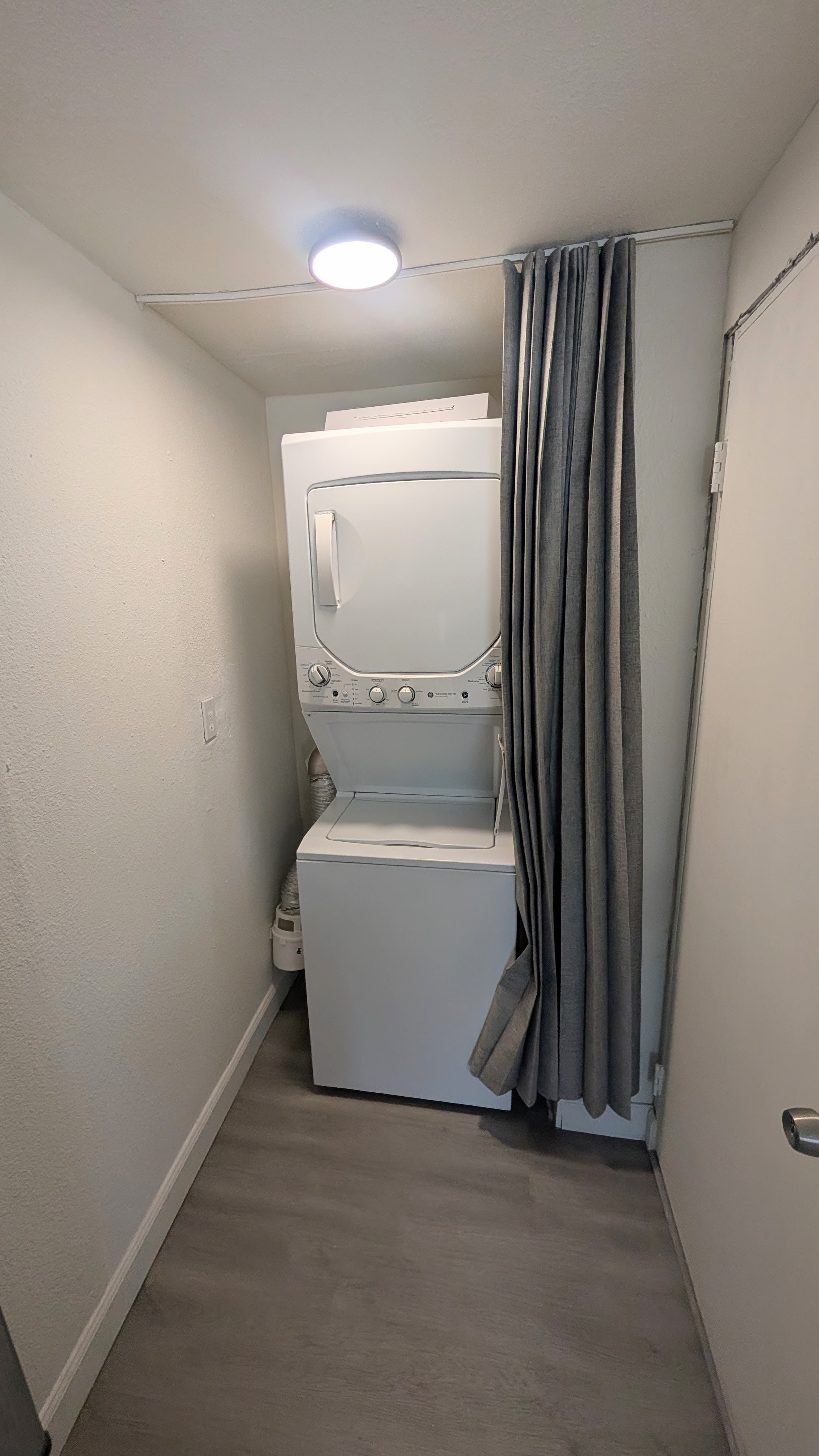 Laundry area with included stacked washer and clothes dryer