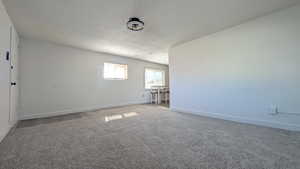Spare room featuring carpet and a textured ceiling