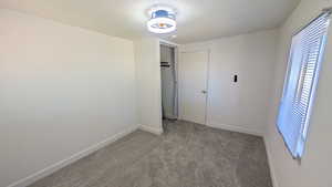 Unfurnished bedroom with carpet, a closet, and a textured ceiling