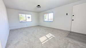Carpeted spare room featuring baseboards