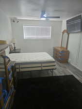 Bedroom with dark wood-style flooring and a ceiling fan