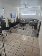 Living area featuring light tile patterned flooring and ceiling fan