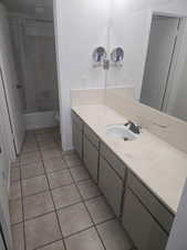 Bathroom featuring vanity, light tile patterned floors, and shower / bath combo with shower curtain