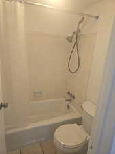 Bathroom featuring shower / bath combo with shower curtain and tile patterned flooring