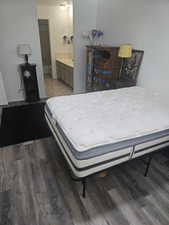 Bedroom featuring dark wood finished floors and ensuite bathroom